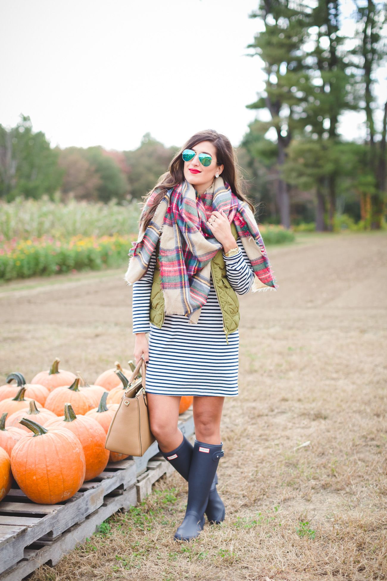 plaid blanket scarf, what to wear to a pumpkin patch, fall pumpkin patch, fall fashion, fall style, fall preppy outfit, quilted vest, excursion vest, stripe dress, hunter boots, tour packable hunter boots, fall blanket scarf, fall outfit ideas // grace wainwright from a southern drawl
