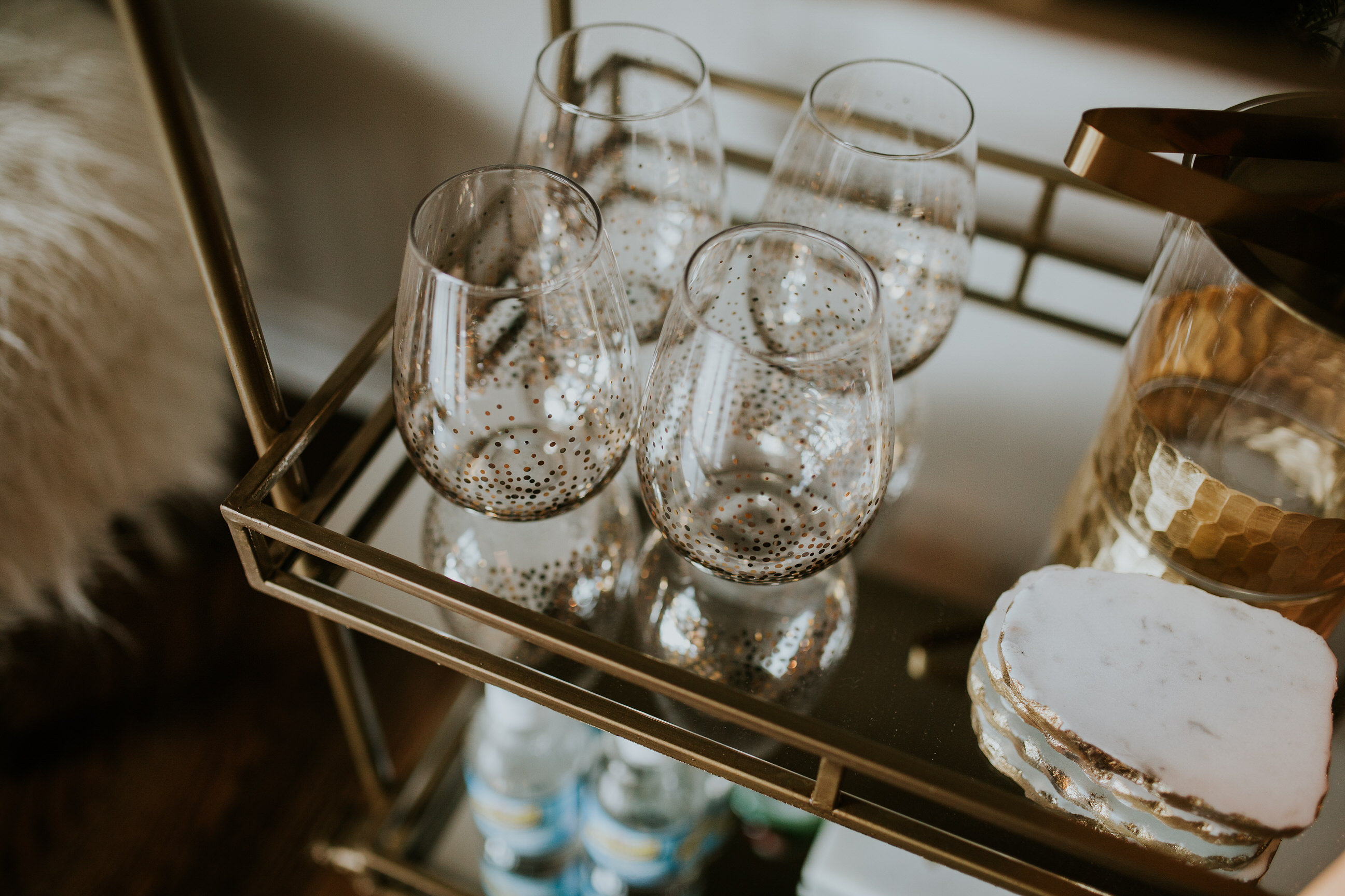 world market bar cart decor, gold bar cart, bar cart target, faux sheepskin stool, faux fur stool, what to put on a bar car, bar cart ideas, holiday hosting, how to host a holiday party, gold champagne glasses, gold rimmed wine glasses, agate coasters // grace wainwright a southern drawl