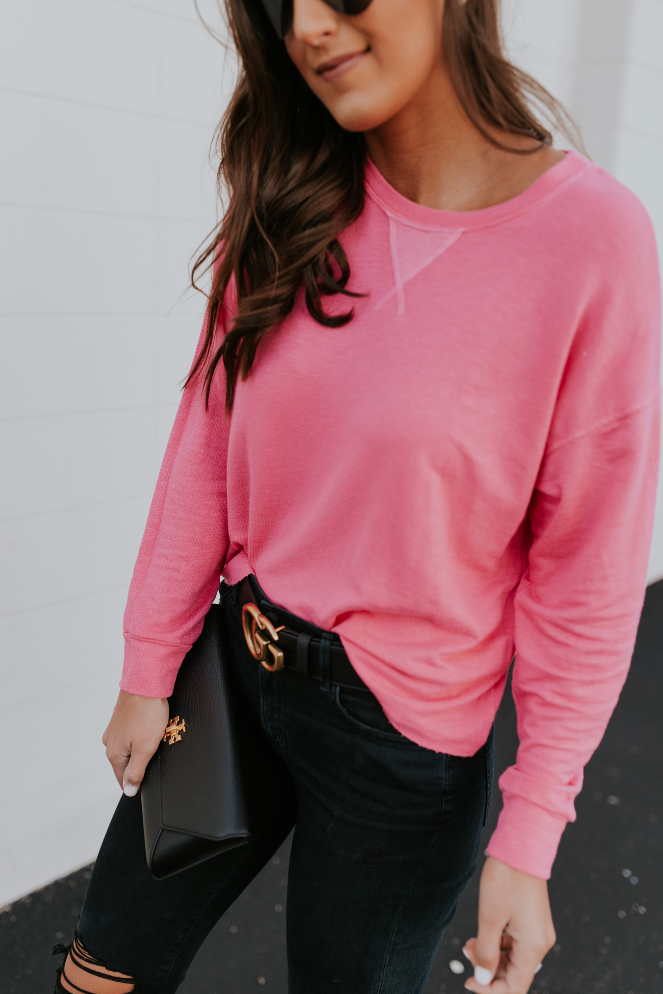 neon pink sweatshirt, cozy style, black distressed jeans, casual fashion, casual outfit, gucci belt, black gucci belt, tory burch kira envelope clutch // grace white a southern drawl